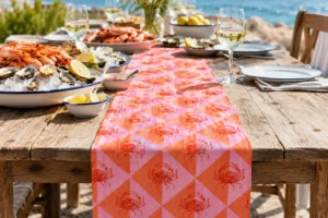 Pink Crab table runner on a weathered wooden table by the sea with prawns, oysters and lemons