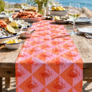 Pink Crab table runner on a weathered wooden table by the sea with prawns, oysters and lemons